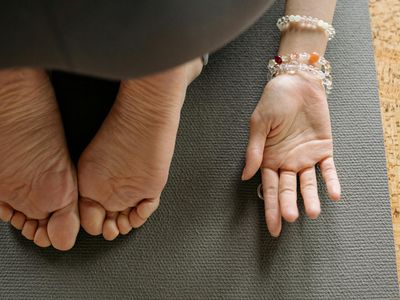 Close up of hands on a yoga mat during meditation.