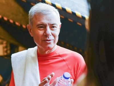 Water bottle and towel placed neatly in a gym setting.